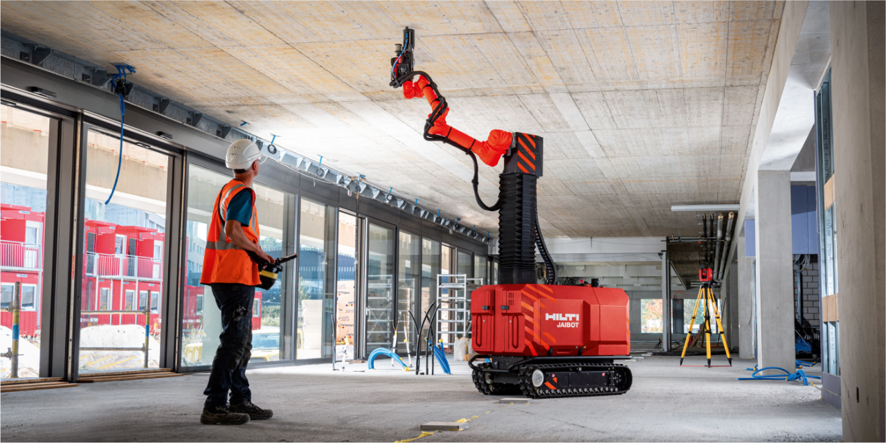Mężczyzna każe Hilti Jaibotowi pracować na suficie. Po prawej stronie pokazano strzałkę, której czerwony koniec wskazuje w prawym górnym rogu.