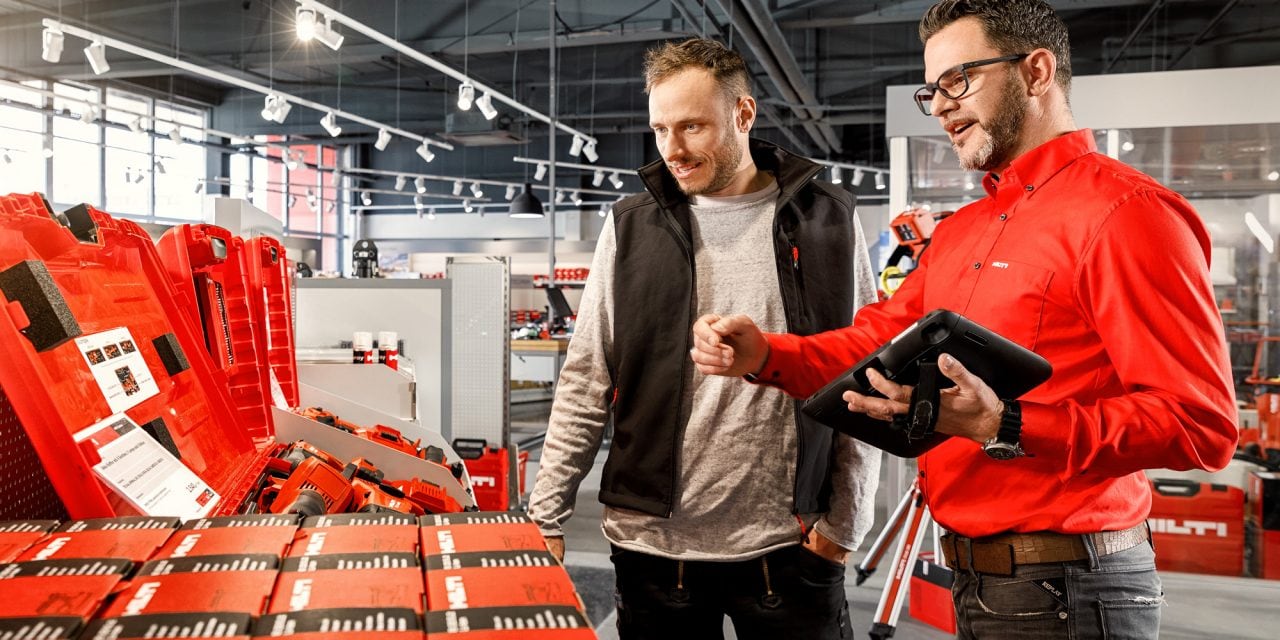 Pracownik sklepu i klient rozmawiający przed otwartymi walizkami