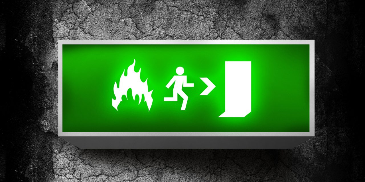 Emergency exit sign Fire emergency exit sign on a grunge obsolete wall