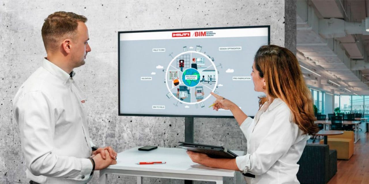 2 pracowników dyskutuje przy ekranie pokazującym bibliotekę PROFIS BIM/CAD